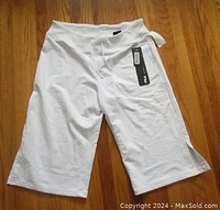 White Fila capri yoga pants with tags visible, laid flat showing front side and waistband drawstring
