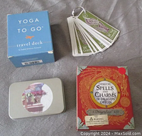 Four mini new age kits laid out: Yoga To Go travel deck boxed, Be the Change mini cards on keyring, Cleansing Kit tin, and Spells & Charms dragon-themed kit.