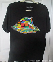 Front view of black t-shirt with a colorful melting Rubik's Cube graphic printed on the center chest area.