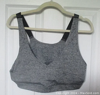 Front view of gray Shein Curve sports bra on hanger showing V-neck and black back straps.