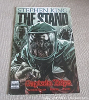 Front cover of Stephen King The Stand Captain Trips comic book, showing characters in hazmat suits reaching forward under title text.