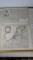 Two antique maps laid out side by side, one appears to be France and the other Netherlands.