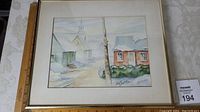 Framed watercolour painting showing a snowy village scene with houses and church steeple, signed Cèline Jacques.
