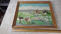 Full view of folk art painting in wooden frame, showing spring apple blossom countryside scene.