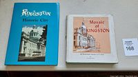 Two hardcover books side by side: 'Kingston Historic City' and 'Mosaic of Kingston'