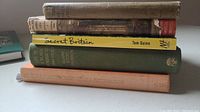 Stack of five hardcover books with visible titles 'Secret Britain', other volumes in varying colors including orange and green.