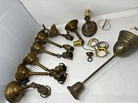 Overhead view of seven bronze hanging fixtures, assorted sockets, rings and hardware
