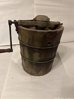 Front view of the antique White Mountain ice cream maker showing wooden bucket and hand crank.