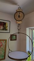 Full view of John Chatillon & Sons antique spring scale hanging with the round weighing pan attached.