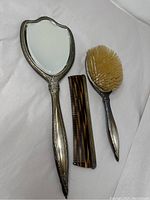 Front of mirror showing bevelled glass and ornate silver handle