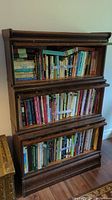 Front view of the stacked three-section bookcase loaded with books