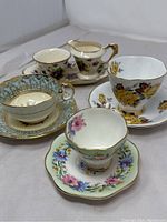 All items in the set arranged together: three teacups with matching saucers, one milk jug and one sugar bowl on a tray