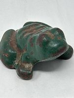 Cast iron green frog door stop showing wear and rust spots, different angles.