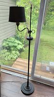 Full view of the vintage black metal floor lamp showing height, arm, and lampshade.