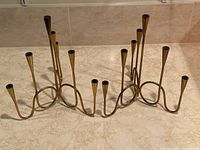 Pair of brass candlesticks on marble countertop showing overall shape and patina