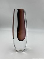 Front view showing clear outer glass and amber inner core, sticker visible on base.