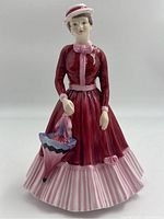 Front angle of Paragon figurine showing red and pink dress, parasol, and hat details.