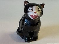 Front angle of the black and white cat figurine showing detailed facial features and glossy finish.