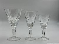 Three sizes of cut crystal stemware glasses: large champagne coupe, medium wine, and small cordial glass