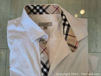 Folded white Burberry shirt showing check pattern inside collar and placket