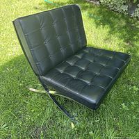 Assembled chair showing seat and back cushions on stainless steel frame
