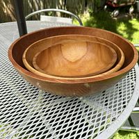 Three nested wooden Baribocraft bowls shown stacked to display size differences and wood grain.
