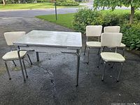 Full view of table with four chairs showing overall design and condition.