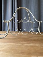 Front and side view showing full metal wine rack with curved artistic design and painted finish.