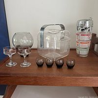 Full lot photo showing all items: 2 large stemmed glasses, 4 smoked shot glasses, lucite ice bucket, large balloon glass, Hazel Atlas cocktail shaker.