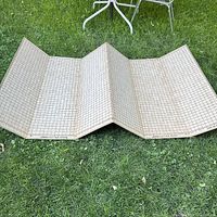 Full view of the vintage Collins cutting board unfolded on grass showing the full grid pattern and fold lines.