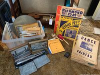 Assorted instruments, posters, framed photos, sheet music and accessories arranged on carpet