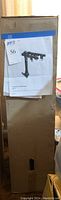 Sealed upright cardboard box with attached printed product sheet showing bike rack image and auction lot tag.