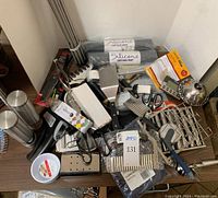Photo showing various grill tools, silicone drying mats, and prep bowls on wooden table, including metal spatulas and pizza cutter.