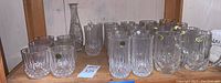 Wide view of all leaded glasses and cut glass vase including 6 short glasses, 12 tall glasses, 8 handled glasses and vase
