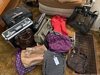 Photo showing a collection of assorted bags including suitcases, work bags, fabric bags, and woven beach totes in various colors and materials.