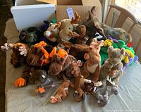 Full view of the lot showing multiple moose and kangaroo stuffed animals arranged on a table