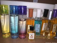 Front view of 11 assorted Jean Philippe fragrance bottles showing different colors and capped spray bottles with visible labels such as Passion of Chanel Chance and White Diamonds.
