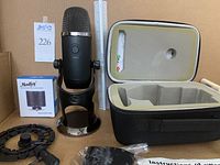 Front view of Blue Yeti microphone on desk mount next to Moukey pop filter box, shock mount, hard case, and instruction sheet