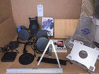 Wide angle photo showing all items in the lot including wireless chargers, various stands, stylus, headset and accessories.