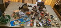 Overview of lot spread on table showing multiple plush Taz toys, collectibles, stickers, and boxed items.