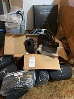 Tesla Wall Connector in box with coiled cable and plastic cord rest mount visible