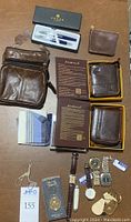 Full lot overview showing wallets, pens, pouch, keychains, watches, small scissors, cloths.