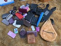 Overview photo showing all items laid out including leather sling bag, crossbody, many wallets and small purses