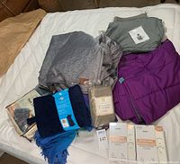 Full view of lot showing weighted blankets, Pendleton duvet cover, skincare pillowcases, king jersey pillowcases, and a blue throw and other textiles.