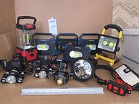Photo of all lights and headlamps arranged with a ruler for scale, showing the various types and brands in the lot