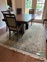 Area rug placed under a dining table showcasing the rug's size, color, and pattern.