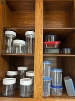 Glass jars with white lids arranged on wooden shelves, various sizes