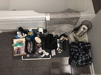 Full view of the entire lot including robe, bath mat, toiletry bags, grooming tools, and personal care items arranged on the floor.