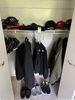 Closet view showing assorted jackets, coats and shoes at the bottom.