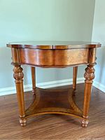 Full view of the occasional table showing the turned and carved legs, drawer, and lower shelf.